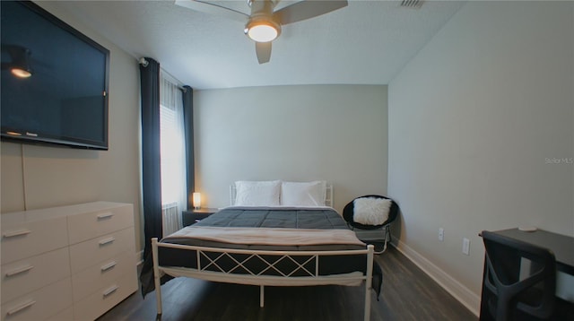 bedroom featuring ceiling fan, dark hardwood / wood-style floors, and a textured ceiling