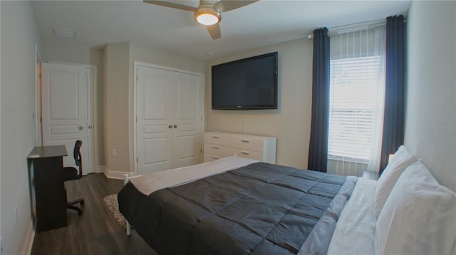 bedroom with dark wood-type flooring, ceiling fan, and a closet