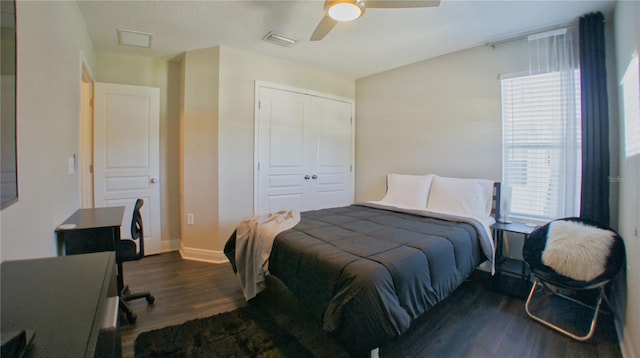 bedroom featuring dark wood-type flooring, a closet, and ceiling fan