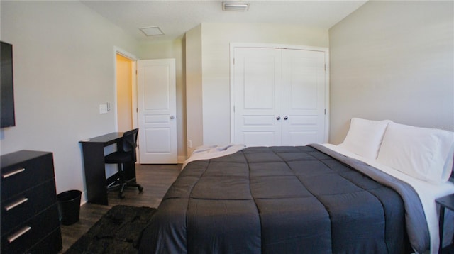 bedroom featuring dark wood-type flooring and a closet