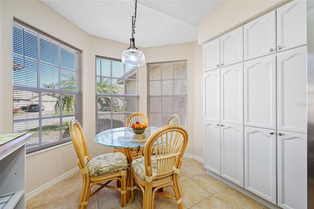 dining room featuring a wealth of natural light, light tile patterned floors, and a textured ceiling