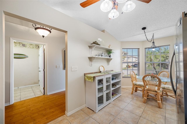 tiled dining room featuring ceiling fan and a textured ceiling