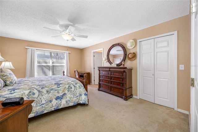 carpeted bedroom featuring ceiling fan, a closet, and a textured ceiling