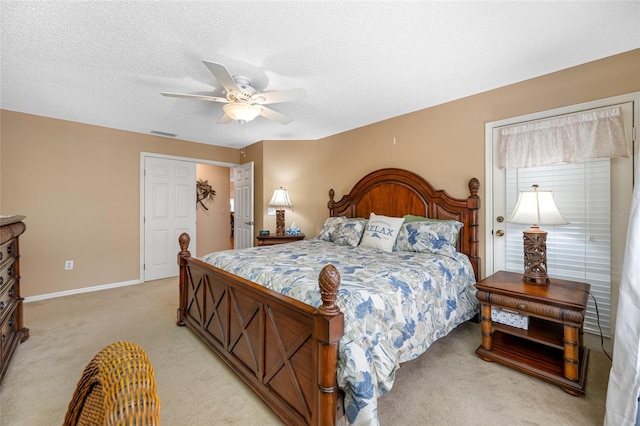 carpeted bedroom with ceiling fan and a textured ceiling