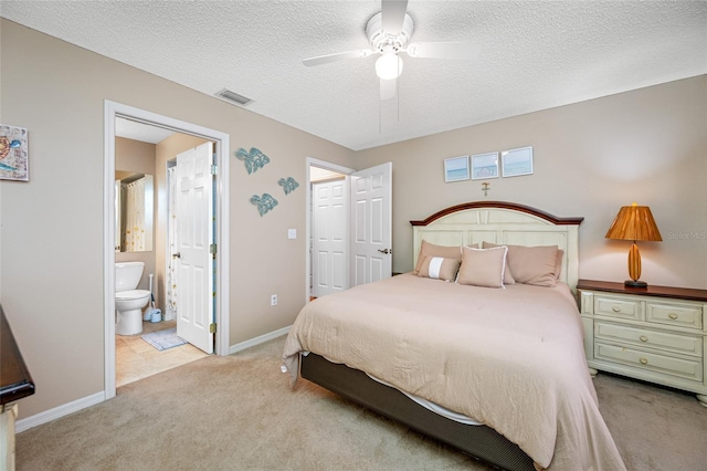 carpeted bedroom with ceiling fan, a textured ceiling, and ensuite bathroom