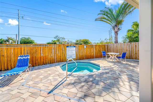 view of swimming pool with a hot tub and a patio