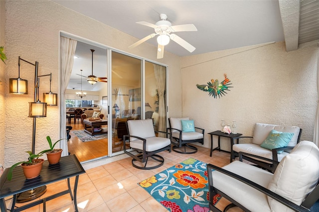 interior space with tile patterned flooring and ceiling fan with notable chandelier