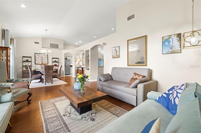 living room with dark hardwood / wood-style floors, a notable chandelier, and high vaulted ceiling