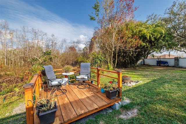 wooden terrace with a fire pit and a lawn