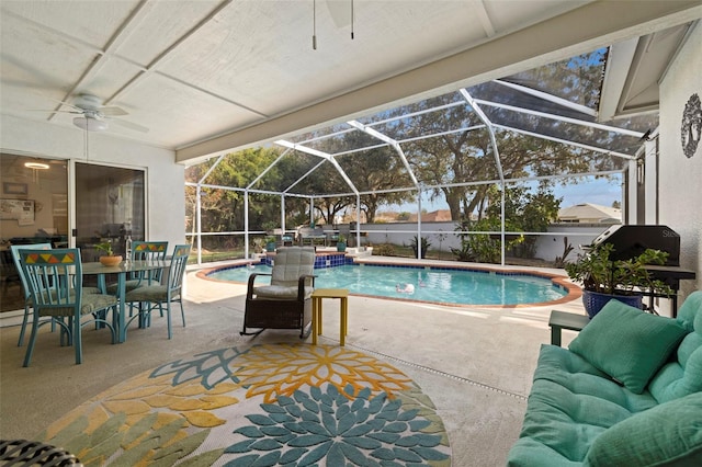 view of swimming pool with ceiling fan, glass enclosure, and a patio area