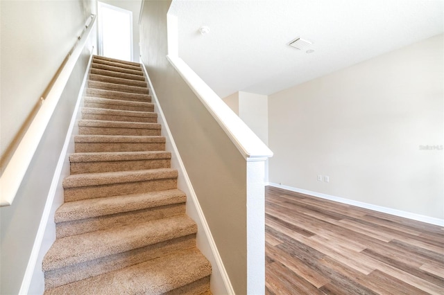 staircase featuring wood-type flooring