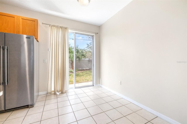 kitchen featuring high end refrigerator and light tile patterned floors