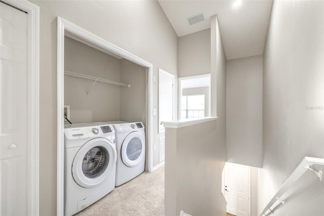 washroom with separate washer and dryer and light colored carpet