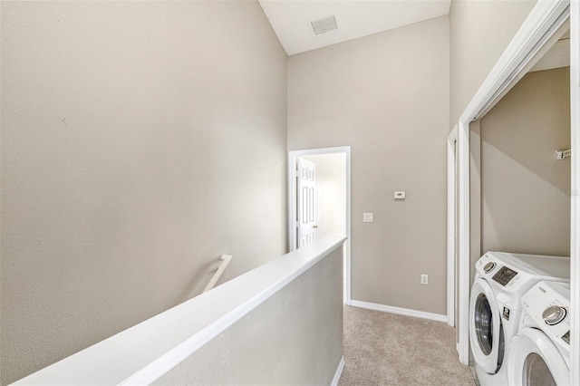 laundry room featuring light carpet and washer and clothes dryer