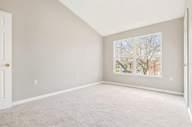 unfurnished room featuring lofted ceiling and carpet