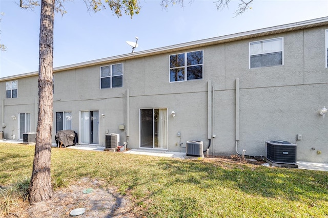 rear view of property with a lawn and central air condition unit