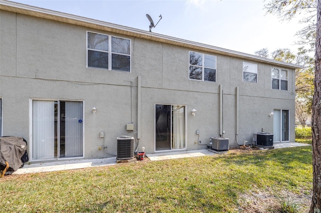 back of property featuring central AC and a yard