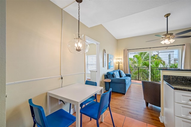 dining room featuring ceiling fan with notable chandelier and light hardwood / wood-style floors