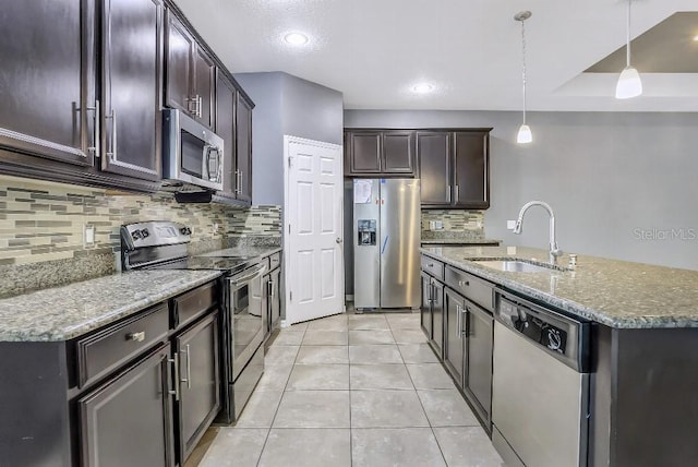 kitchen featuring decorative light fixtures, sink, light tile patterned floors, light stone counters, and stainless steel appliances