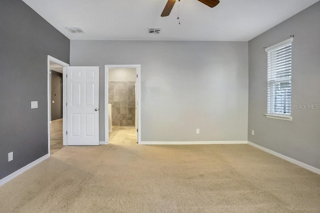 unfurnished bedroom with light carpet, ceiling fan, and ensuite bathroom