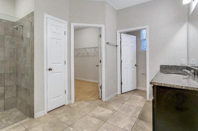 bathroom featuring tiled shower, tile patterned floors, and vanity