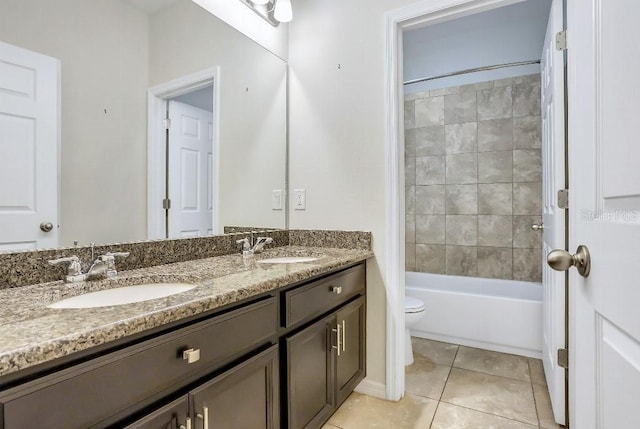 full bathroom featuring tile patterned flooring, vanity, tiled shower / bath, and toilet