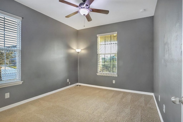 carpeted spare room with ceiling fan