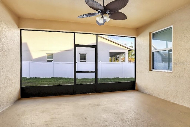 unfurnished sunroom featuring ceiling fan