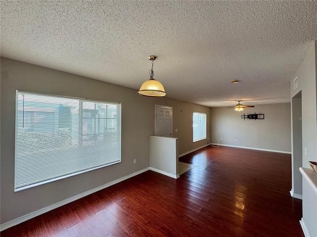 unfurnished room with dark hardwood / wood-style floors, a textured ceiling, and ceiling fan