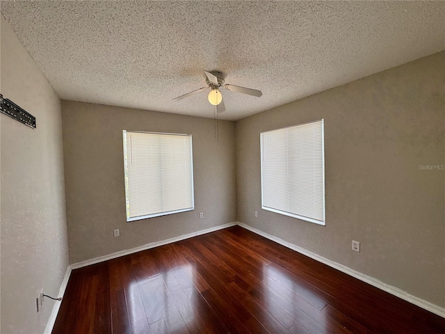 empty room with ceiling fan, dark hardwood / wood-style floors, and a textured ceiling