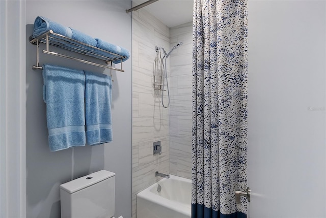 bathroom featuring shower / tub combo and toilet