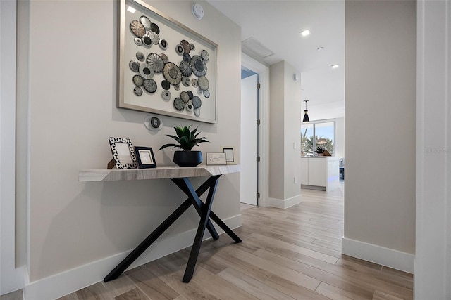 hallway with light hardwood / wood-style floors