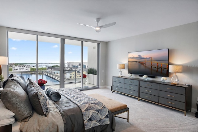 bedroom featuring expansive windows, ceiling fan, access to exterior, and light carpet