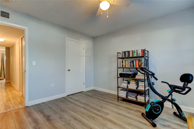 exercise room featuring wood-type flooring and a textured ceiling