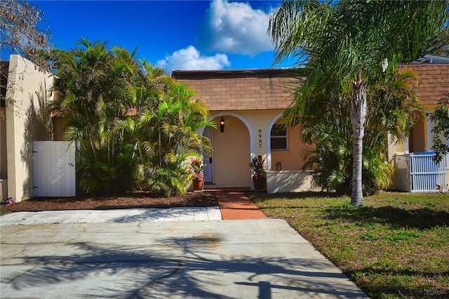 mediterranean / spanish-style house with a front yard