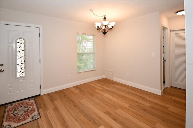 entrance foyer featuring light hardwood / wood-style floors and a chandelier