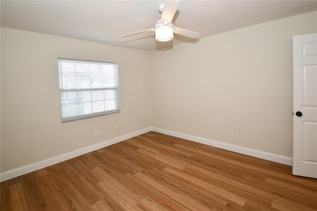 empty room with hardwood / wood-style flooring, ceiling fan, and a textured ceiling