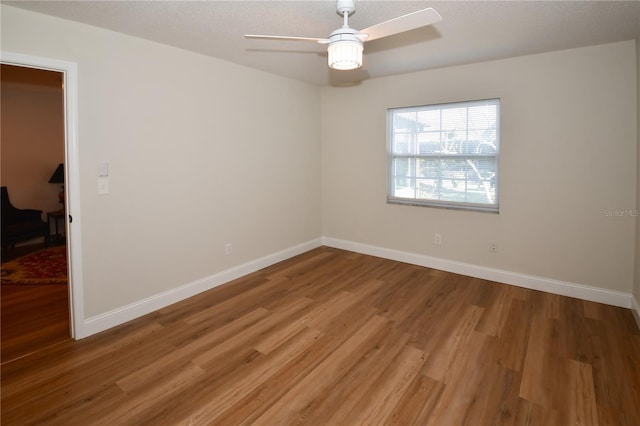 spare room featuring ceiling fan, wood-type flooring, and a textured ceiling