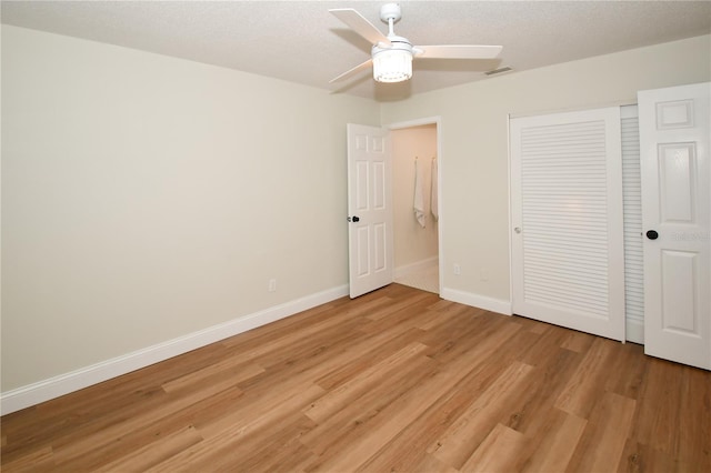 unfurnished bedroom with a textured ceiling, light hardwood / wood-style floors, a closet, and ceiling fan