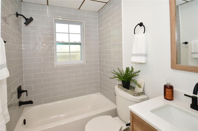 full bathroom featuring vanity, tiled shower / bath, and toilet