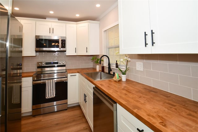 kitchen with butcher block countertops, sink, and appliances with stainless steel finishes