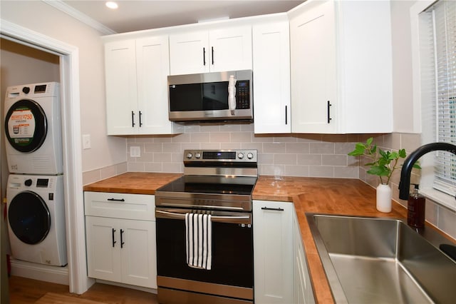 kitchen featuring appliances with stainless steel finishes, butcher block counters, sink, and white cabinets