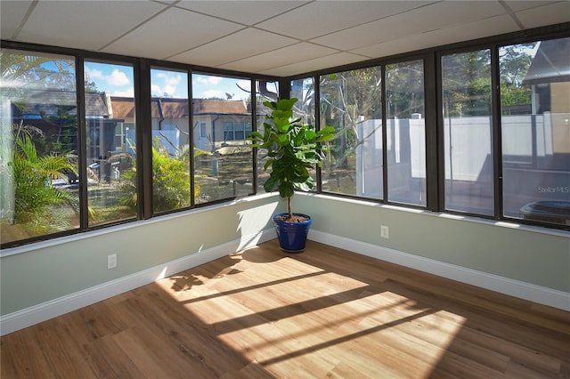 unfurnished sunroom featuring a paneled ceiling and plenty of natural light