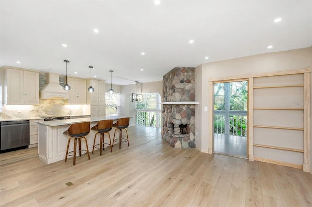 kitchen with a large island, pendant lighting, dishwasher, backsplash, and custom range hood