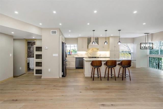 kitchen featuring premium range hood, pendant lighting, backsplash, a large island, and stainless steel appliances