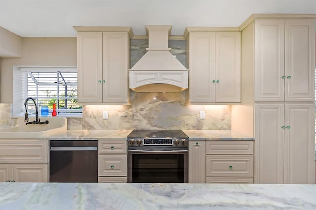 kitchen featuring sink, appliances with stainless steel finishes, tasteful backsplash, custom exhaust hood, and cream cabinetry