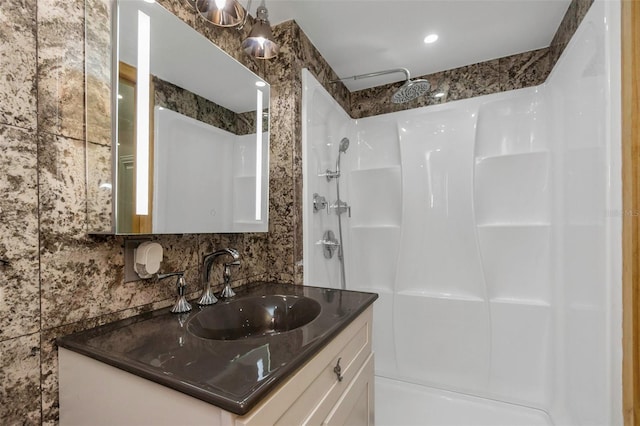 bathroom with vanity, backsplash, and walk in shower