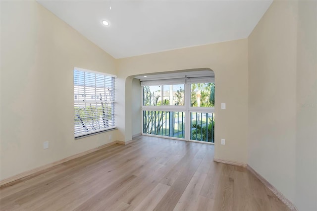 spare room featuring high vaulted ceiling and light hardwood / wood-style floors