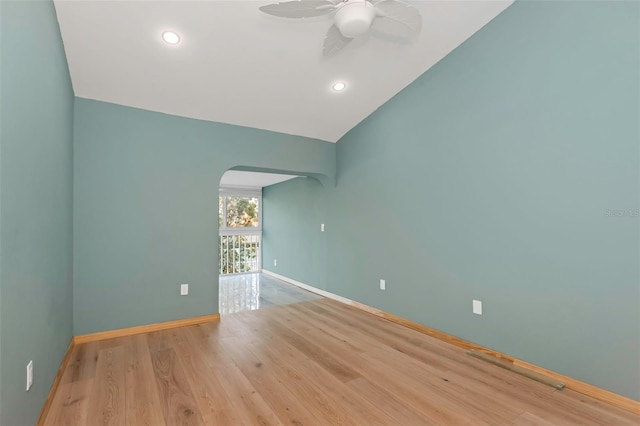 spare room with lofted ceiling, ceiling fan, and light hardwood / wood-style flooring