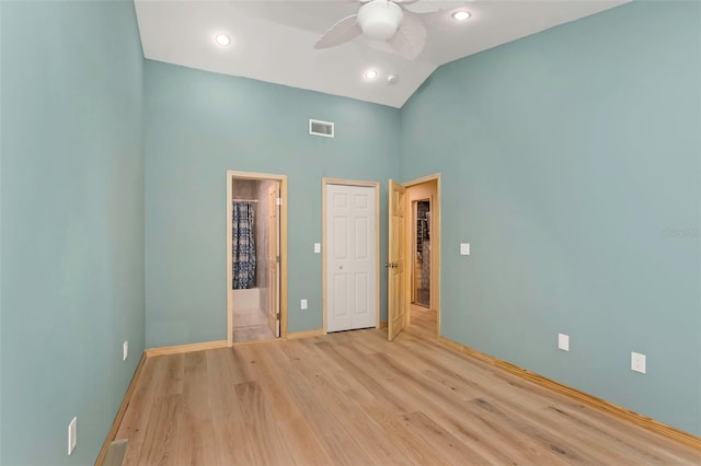 unfurnished bedroom featuring ceiling fan, lofted ceiling, ensuite bath, and light hardwood / wood-style flooring